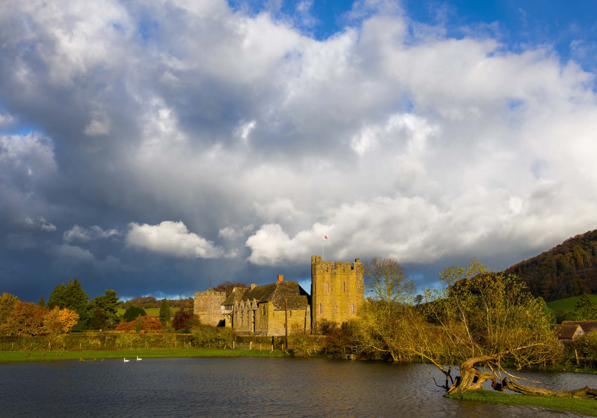 Stormy skies over the fortified medieval manor house of Stokesay Castle and St John the Baptist's church in autumn, Shropshire, England.