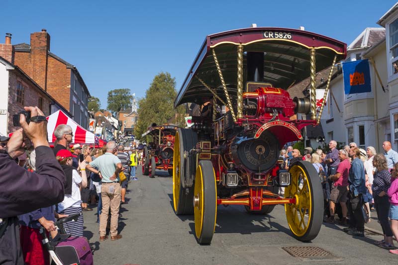 Traction engines parade down High Street at the Bishop's Castle Michaelmas Fair, Shropshire.
